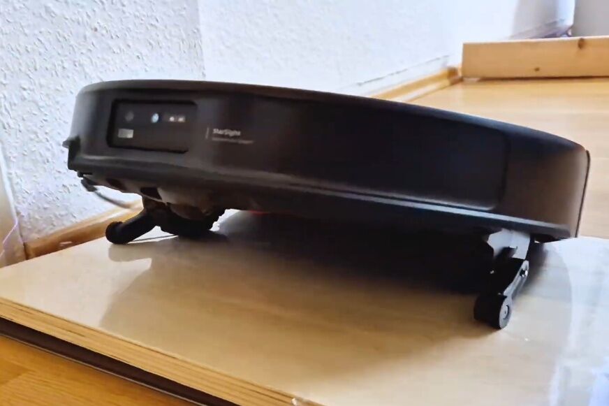 Roborock Saros 20 klettert mit ausgefahrenen Beinchen über eine hohe Türschwelle